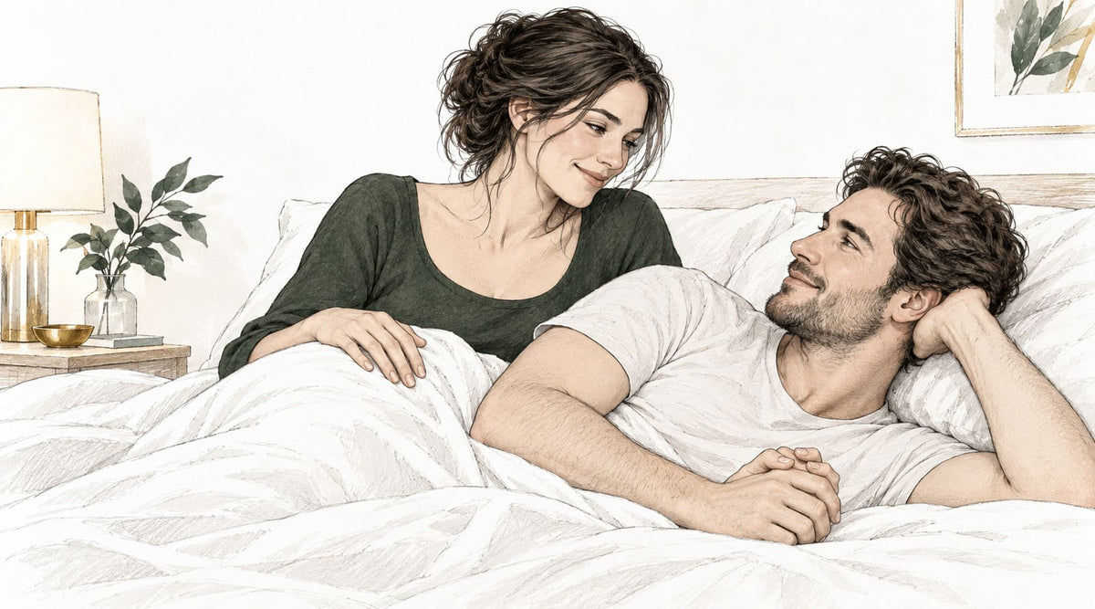 Couple adulte échangeant un regard complice dans un lit avant un doigtage anal